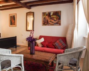 a living room with a red couch and a table at Apartments Hemingway House in Kobarid
