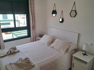 sypialnia z białym łóżkiem i oknem w obiekcie Casita A Pitisa w mieście Playa Blanca