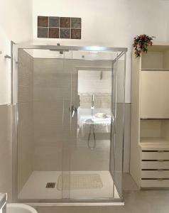 a shower with a glass door in a bathroom at Baia delle foche in Fertilia
