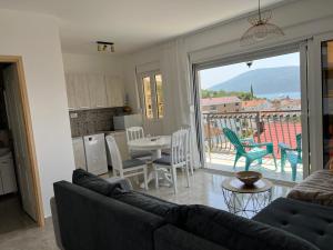 a living room with a couch and a table with chairs at Fortunella Apartments in Herceg-Novi