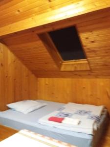 uma cama num quarto de madeira com uma televisão no tecto em Apartment Orah em Subotica