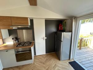 a small kitchen with a refrigerator and a stove at DS Chalets-Simonsgat 63-Geweldige 6 tot 7 persoons chalet met 2 badkamers-vakantiepark Lauwersoog-aan het Lauwersmeer in Lauwersoog