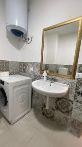a bathroom with a sink and a washing machine at APPARTAMENTO MAESTRALE in Balestrate