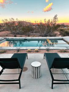 ジョシュア・ツリーにあるJoshua Tree Pool & Pickleball- Mojave Paddle Clubのスイミングプール(椅子2脚、テーブル付)