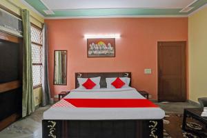 ein Schlafzimmer mit einem großen Bett mit orangefarbenen Wänden in der Unterkunft OYO Flagship 81046 Royal Retreat in Gurgaon
