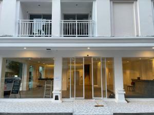 Edificio blanco con puertas de cristal y balcón en Odin Andaman Hotel en Patong