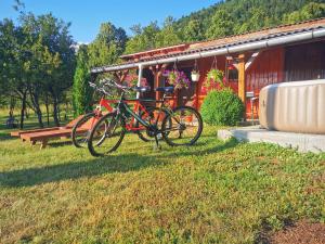 dos bicicletas estacionadas en el césped frente a un edificio en Holiday Home La Sierra, en Korenica