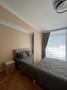 ein Schlafzimmer mit einem Bett und einem großen Fenster in der Unterkunft Two bedroom lux apartment in Budva