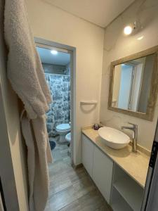 a bathroom with a sink and a toilet and a mirror at Lincoln Relax in Lincoln