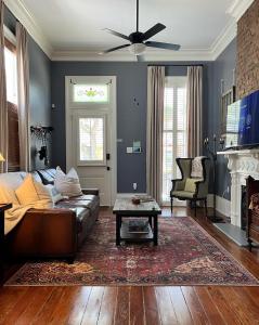 een woonkamer met een bank en een tafel bij Luxury Historic Shotgun Home in Lower Garden District in New Orleans