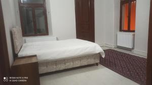 a bedroom with a bed and a red rug at Hamza Nezir malikanesi (Hane) in Trabzon