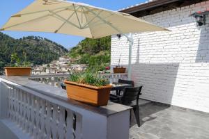 patio con mesa y sombrilla en el balcón en Villa Dona, en Berat