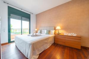 ein Schlafzimmer mit einem großen Bett und einem großen Fenster in der Unterkunft Villa Margot Lux, ideal familias, piscina & Aircon in Lloret de Mar