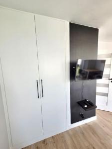 a white cabinet with a tv in a room at City Centre top floor Apartment in Warsaw