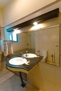 une salle de bain avec un lavabo et un grand miroir dans l'établissement Renaissance Hotels, à Islamabad
