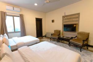 a living room with a couch and a tv at Renaissance Hotels in Islamabad