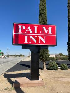 a red painimim sign on the side of a road at Palm Inn in Mojave