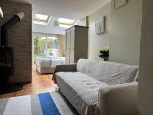 sala de estar con sofá y chimenea en Centre of Killaloe Village, Lovely Apartment en Killaloe