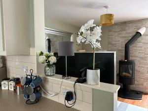 a kitchen with a fireplace and flowers on a counter at Centre of Killaloe Village, Lovely Apartment in Killaloe