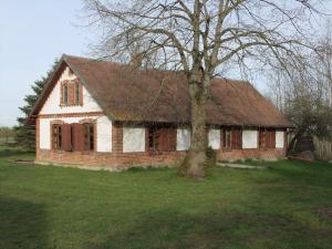 une vieille maison en briques avec un arbre dans un champ dans l'établissement Sodyba Suvernų kaime, à Ventė