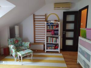 a living room with a chair and a book shelf at Family house by the Sziget festival in Budapest