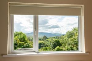 a window with a view of the mountains at Bradleys Cottage Creeslough in Creeslough