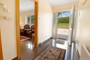 a hallway with a door open to a living room at Bradleys Cottage Creeslough in Creeslough