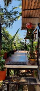 a wooden walkway with potted plants on it at Bageecha B&B- Vaayu in Alibaug