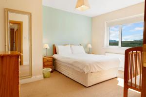 a bedroom with a large bed and a window at Bradleys Cottage Creeslough in Creeslough