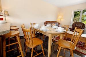 a dining room with a wooden table and chairs at Bradleys Cottage Creeslough in Creeslough