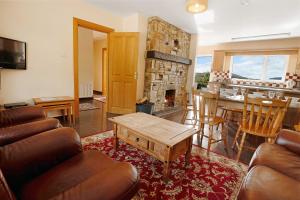 a living room with a couch and a table at Bradleys Cottage Creeslough in Creeslough