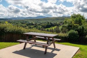 a picnic table with a view of a valley at Bradleys Cottage Creeslough in Creeslough