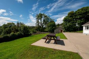 a picnic table sitting on the grass next to a sidewalk at Bradleys Cottage Creeslough in Creeslough