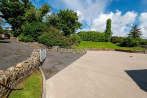 a driveway with a stone fence and a path at Bradleys Cottage Creeslough in Creeslough