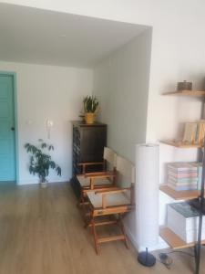 a living room with wooden floors and a table and shelves at Furadouro Cool & Cozy Flat in Furadouro