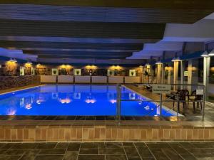 a large blue pool in a building at night at Ferienwohnung Paula in Bad Harzburg