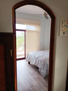 - une chambre avec un lit et une porte ouverte dans l'établissement “Casa Juanita”, à Lo de Marcos
