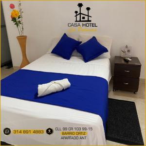 een bed met blauwe en witte lakens en blauwe kussens bij Casa Hotel La Palmera Apartadó in Apartadó