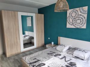 ein Schlafzimmer mit einem Bett und einem großen Spiegel in der Unterkunft Maison d'hôtes naturiste in Ville-sur-Yron