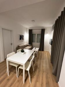 een eetkamer met een witte tafel en stoelen bij Lumi Apartments in Gevgelija