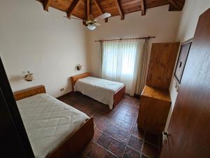a small bedroom with two beds and a window at Casa de Campo N 2 en Barrio Posta Carreta, Santa Rosa de Calamuchita in Atos Pampa