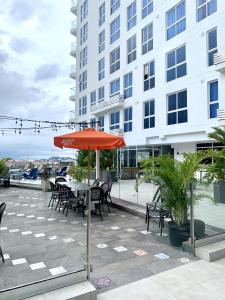 een patio met een tafel en stoelen en een parasol bij Moderno Apartamento en Avenida Balboa in Panama-Stad