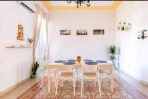 una sala da pranzo bianca con tavolo e sedie di Merlo House a Palermo