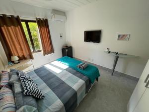 ein Schlafzimmer mit einem Bett, einem Sofa und einem TV in der Unterkunft Angra dos Reis - Porto Bali - SUÍTE no Porto Bali Resort in Angra dos Reis