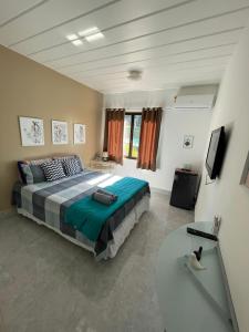 um quarto com uma cama, uma mesa e uma televisão em Angra dos Reis - Porto Bali - SUÍTE no Porto Bali Resort em Angra dos Reis