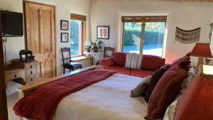Tussock Cottage في كوينزتاون: غرفة نوم بسرير كبير وغرفة معيشة