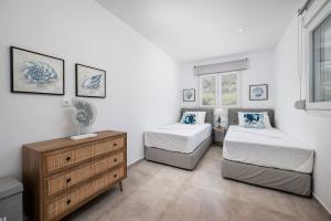 Un dormitorio con dos camas y una cómoda. en Thalassa Beach House, en Kefalos