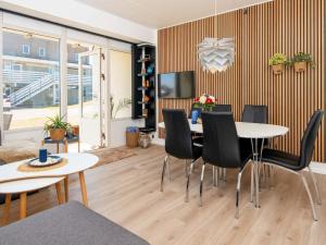a living room with tables and chairs and a tv at 4 person holiday home in Ringkøbing-By Traum in Ringkøbing