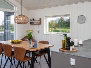 eine Küche mit einem Tisch und Stühlen sowie einem Fenster in der Unterkunft 6 person holiday home in Ansager in Ansager