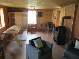 - un salon avec une table, des chaises et une cuisinière dans l'établissement Sodyba Suvernų kaime, à Ventė